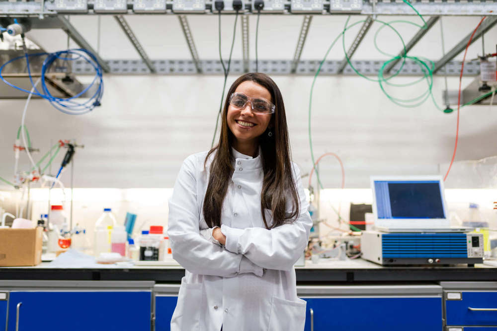 Female chemical engineer in laboratory develops clean energy storage solutions.